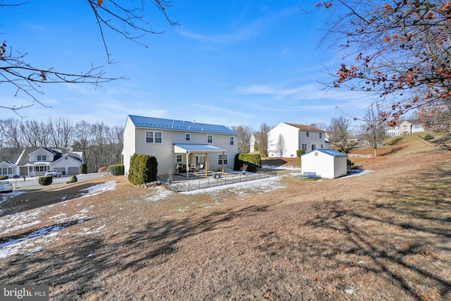 back of house with a yard and a storage shed