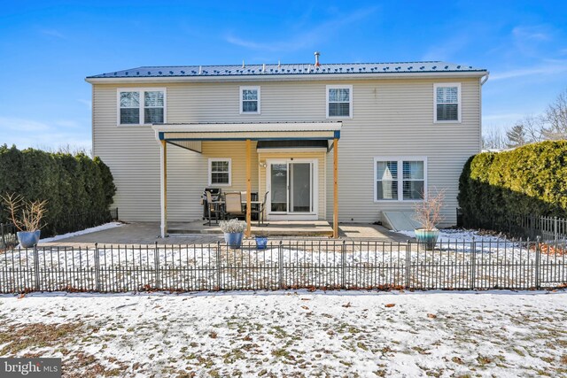 snow covered house with a patio area