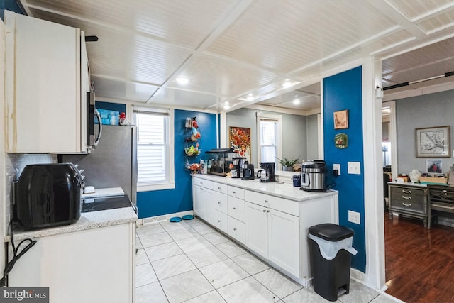 kitchen with white cabinets, light tile patterned floors, and plenty of natural light