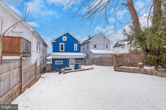 snow covered house with a wooden deck