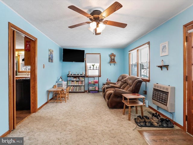 carpeted living room featuring ceiling fan, a textured ceiling, and heating unit