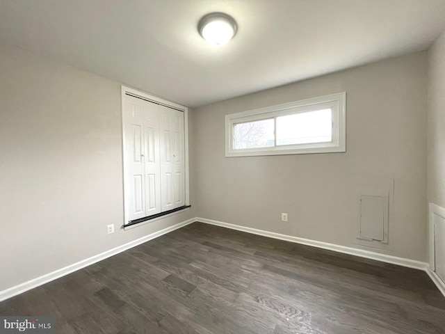 unfurnished bedroom featuring dark wood-type flooring and a closet