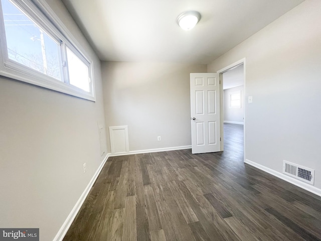 unfurnished room featuring dark wood-type flooring