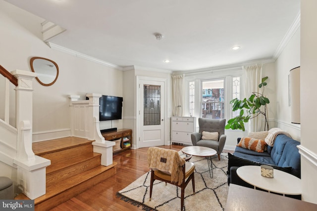 living area with ornamental molding, recessed lighting, wood finished floors, and stairs