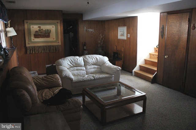 carpeted living room featuring wooden walls