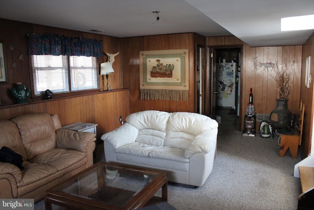 carpeted living room with wood walls