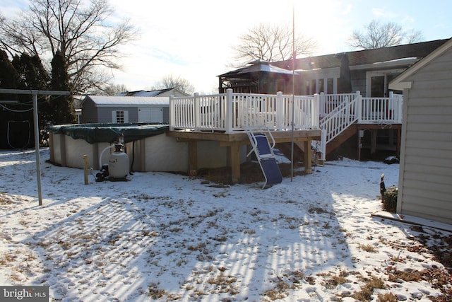 snow covered house with a swimming pool side deck