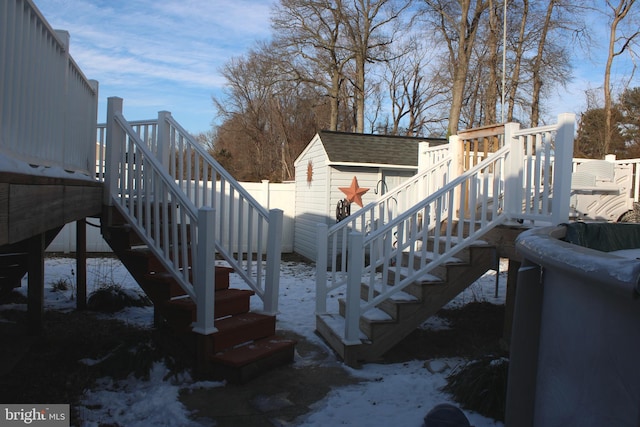 snow covered deck featuring a shed