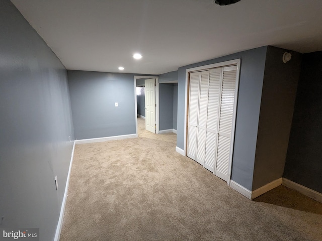 unfurnished bedroom featuring light carpet and a closet