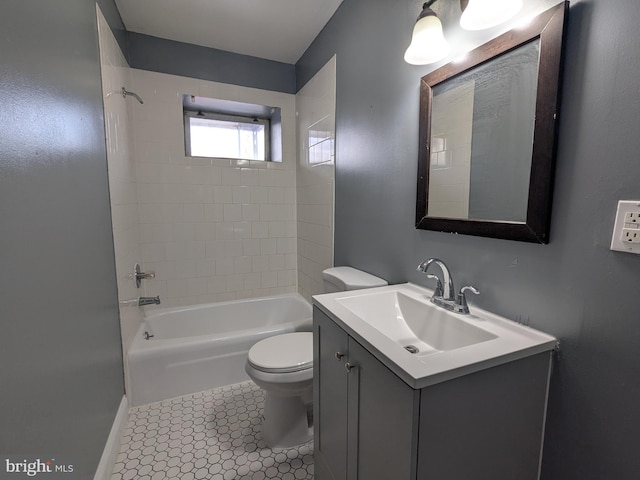 full bathroom with tile patterned flooring, tiled shower / bath, vanity, and toilet