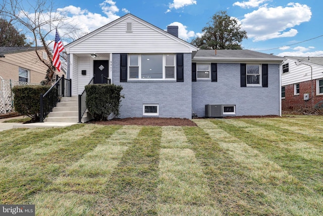 bungalow-style house featuring central AC unit and a front yard