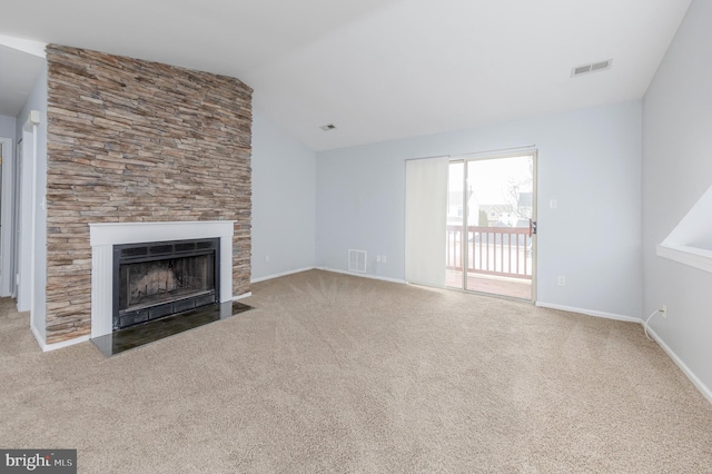 unfurnished living room featuring lofted ceiling, a fireplace, and carpet floors