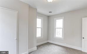 unfurnished bedroom featuring carpet flooring and multiple windows