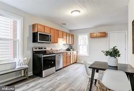 kitchen with light wood-type flooring and stainless steel appliances