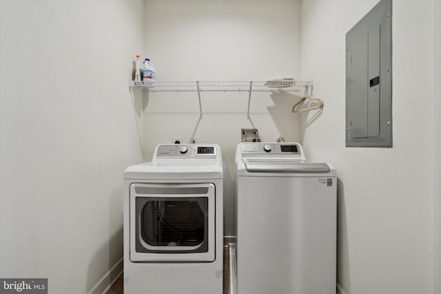 washroom with electric panel and washer and clothes dryer