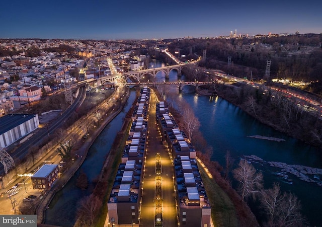 aerial view at dusk featuring a water view