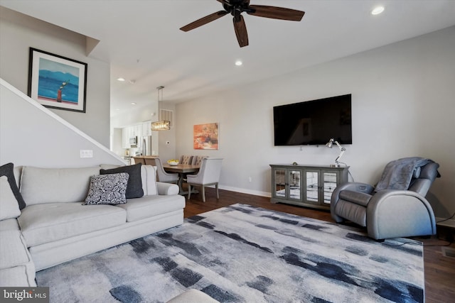 living room featuring hardwood / wood-style floors and ceiling fan with notable chandelier