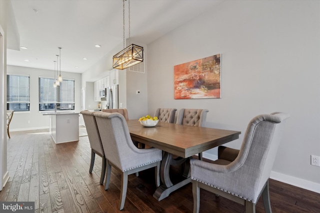 dining space with dark hardwood / wood-style floors and a chandelier