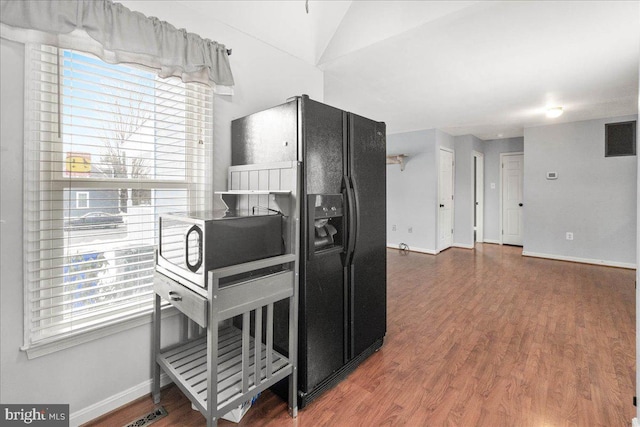 kitchen with hardwood / wood-style floors and black refrigerator with ice dispenser