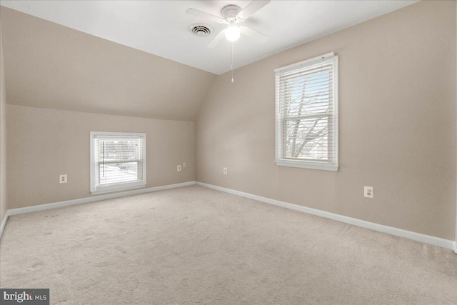 additional living space with light carpet, plenty of natural light, ceiling fan, and lofted ceiling