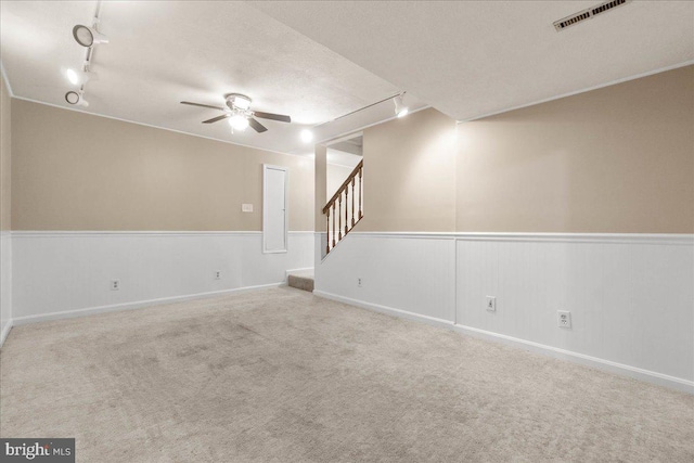 interior space with a textured ceiling, ceiling fan, and rail lighting