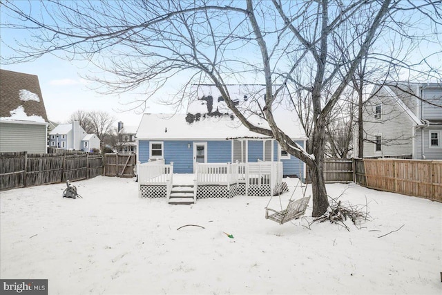 snow covered property with a deck