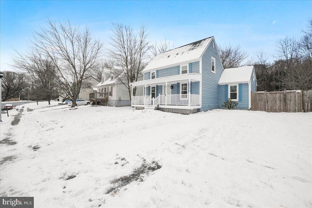 snow covered back of property with covered porch