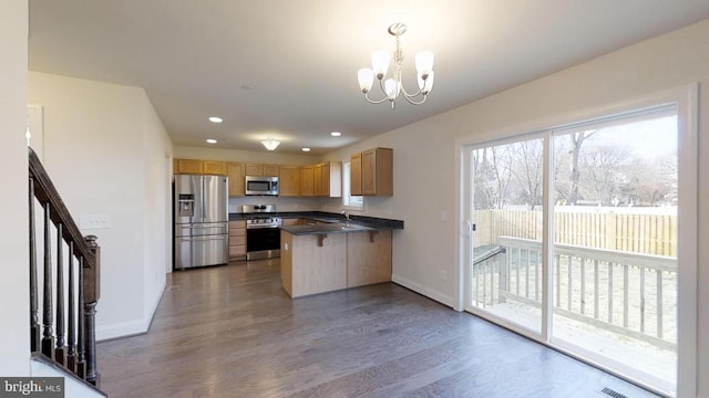 kitchen featuring hanging light fixtures, stainless steel appliances, an inviting chandelier, kitchen peninsula, and a breakfast bar