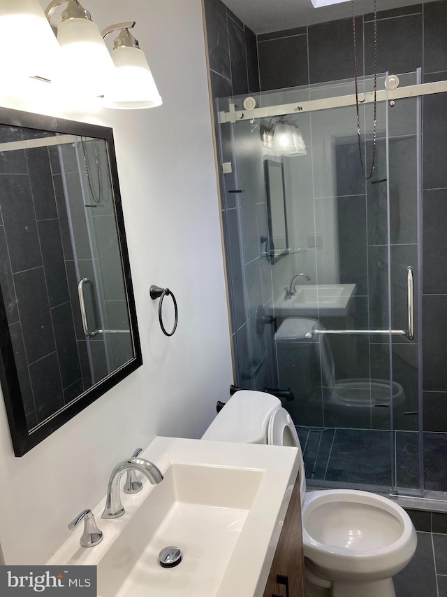 bathroom with vanity, toilet, and a shower with shower door