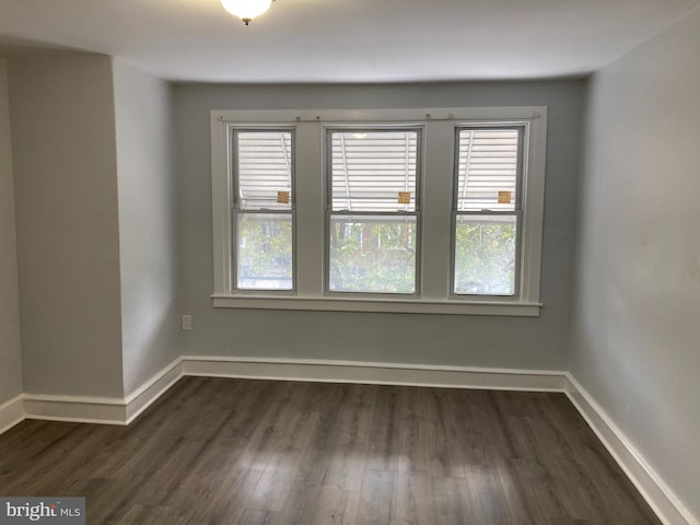 empty room with dark hardwood / wood-style flooring