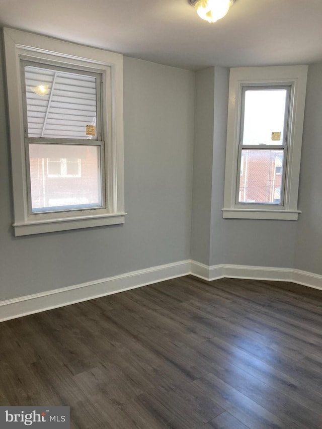 spare room with dark wood-type flooring