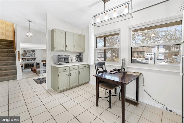 kitchen featuring hanging light fixtures, light tile patterned floors, vaulted ceiling, and green cabinets