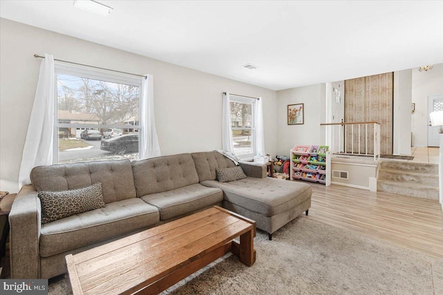 living room with a healthy amount of sunlight and light hardwood / wood-style flooring