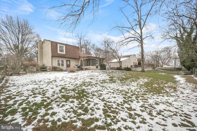 snow covered property featuring a sunroom