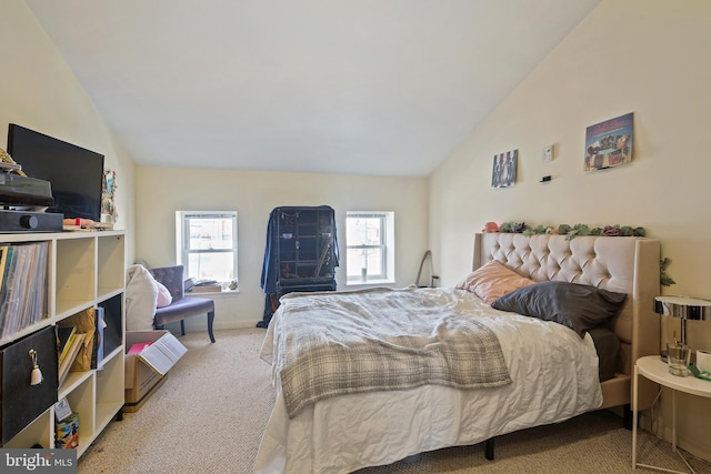 carpeted bedroom featuring baseboards and vaulted ceiling