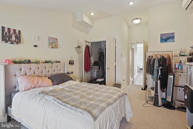 bedroom featuring a walk in closet, an AC wall unit, carpet flooring, and a closet