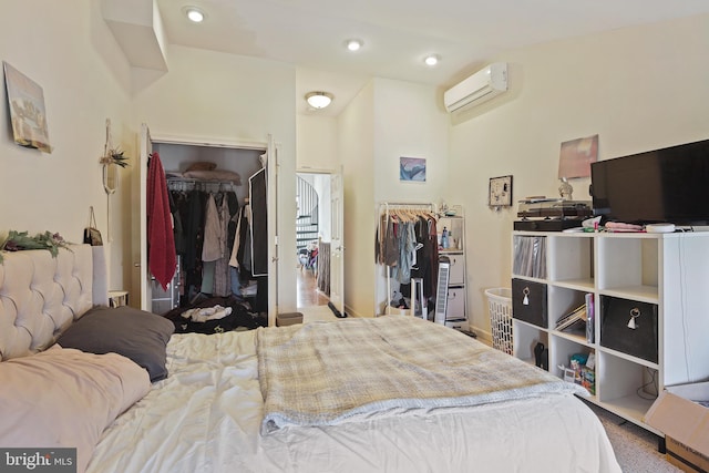 bedroom featuring a wall unit AC, recessed lighting, and a closet