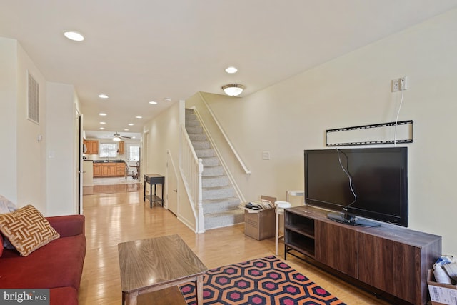 living room with visible vents, light wood-style flooring, recessed lighting, ceiling fan, and stairs