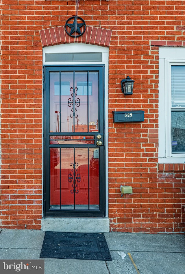 view of exterior entry with brick siding