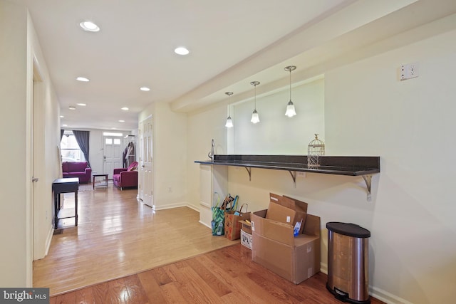 interior space featuring decorative light fixtures, recessed lighting, baseboards, and wood finished floors