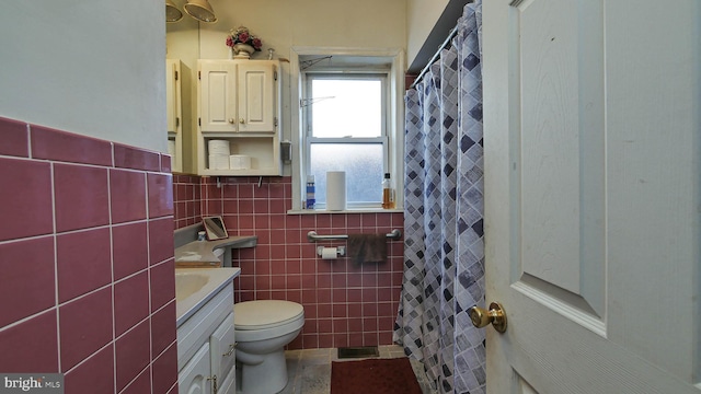 bathroom with tile walls, toilet, and vanity