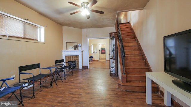 interior space with ceiling fan, hardwood / wood-style flooring, and a tiled fireplace