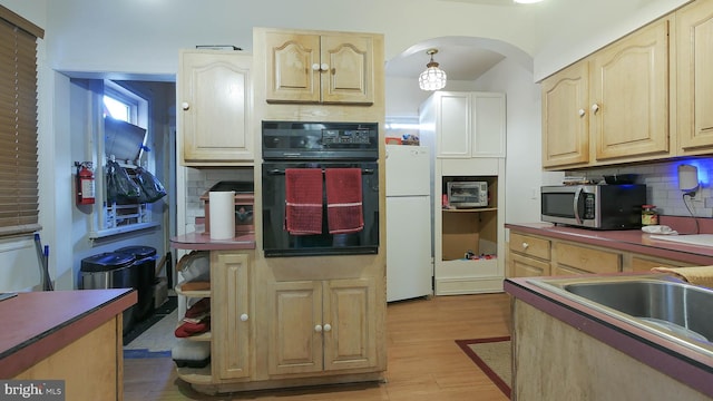 kitchen featuring white fridge, sink, backsplash, oven, and light hardwood / wood-style flooring