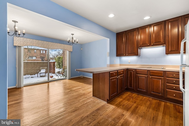 kitchen with kitchen peninsula, pendant lighting, and an inviting chandelier