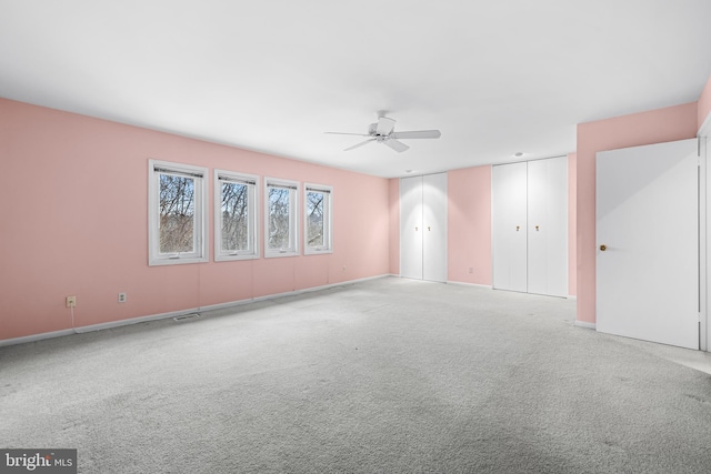 empty room featuring ceiling fan and carpet