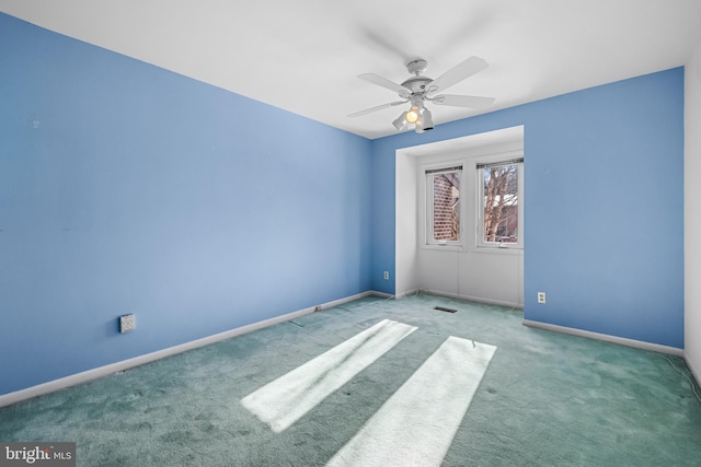 carpeted spare room featuring ceiling fan