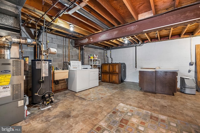 basement featuring separate washer and dryer, water heater, and sink