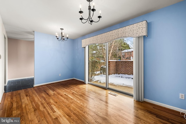 unfurnished dining area featuring a chandelier and hardwood / wood-style flooring