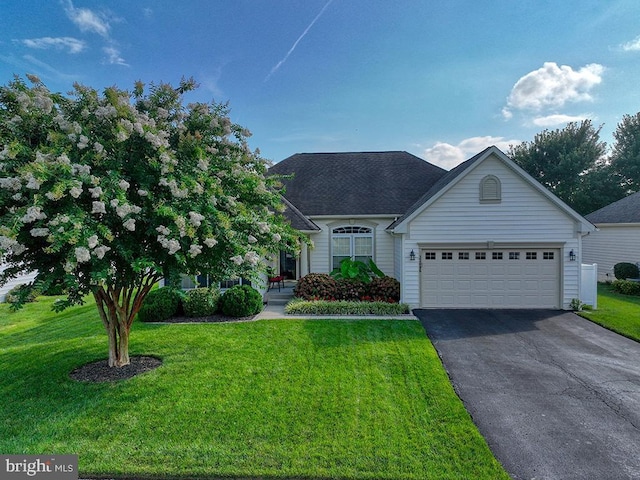 view of front of home with a front yard and a garage