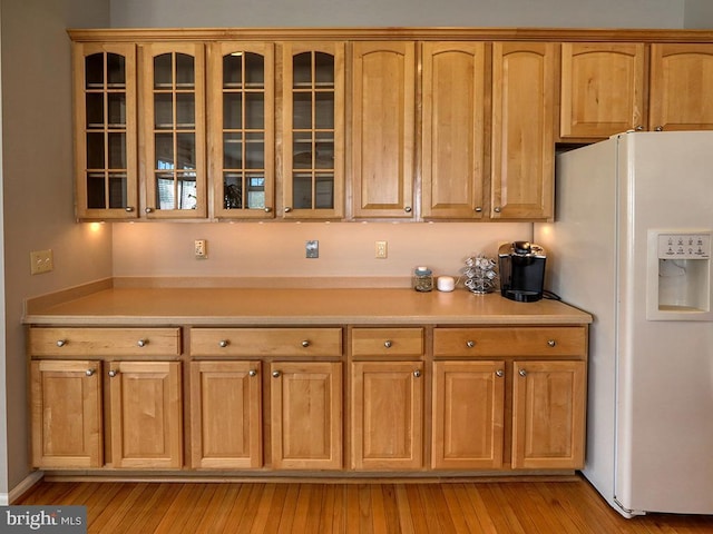 kitchen featuring white refrigerator with ice dispenser and light hardwood / wood-style flooring